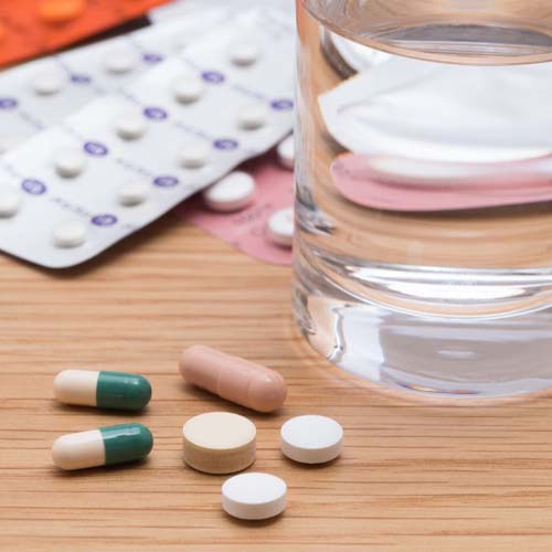 pills and a glass of water next to pills
